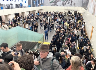 万博会場に向かう人たちで混雑する夢洲駅の出口付近＝13日午後０時半、大阪市此花区