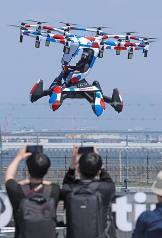 テスト飛行が公開され、パイロットの操縦で飛ぶ空飛ぶクルマ＝１４日午前、大阪市此花区の夢洲（撮影・笠原次郎）
