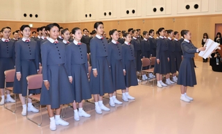 答辞を読み上げる佐藤桜耶さん（右）と新入生たち＝１８日午前、宝塚市武庫川町。宝塚音楽学校（撮影・吉田敦史）