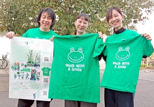 チャリティーウオークで着るＴシャツを手に参加を呼びかけるスタッフ＝神戸市中央区港島中町８