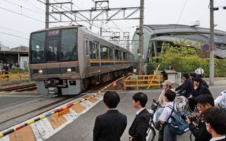 事故から２０年。祈りの杜の前を通過する電車＝２５日午前８時１４分、尼崎市久々知３（撮影・丸山桃奈）