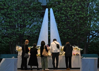 追悼施設「祈りの杜」では、日が暮れた後も献花の列が続いた＝２５日午後６時３３分、尼崎市久々知３（撮影・大田将之）