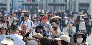 大型連休初日を迎えた大阪・関西万博会場。公式キャラクターミャクミャクのグッズを身に付け、雰囲気を満喫する姿もあった＝２６日午前、大阪市此花区の夢洲（撮影・小林良多）