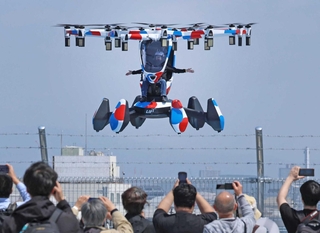 パイロットを乗せてデモ飛行する「空飛ぶクルマ」＝１４日、大阪市此花区（撮影・笠原次郎） 