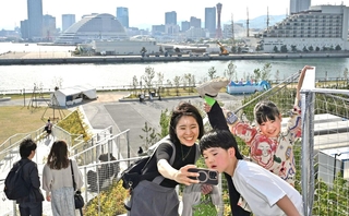「ＴＯＴＴＥＩ　ＰＡＲＫ（トッテイパーク）」の「緑の丘」で記念撮影する人たち＝２７日午後、神戸市中央区新港町（撮影・風斗雅博）
