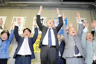 香美町長選で当選確実となり万歳する浜上勇人氏（中央）＝香美町香住区香住