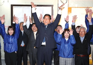 支援者とともに万歳して当選を喜ぶ福元晶三氏（中央）＝２７日夜、宍粟市山崎町山田（撮影・辰巳直之）