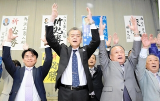 香美町長選で当選確実となり万歳する浜上勇人氏（中央）＝香美町香住区香住（撮影・吉田みなみ）