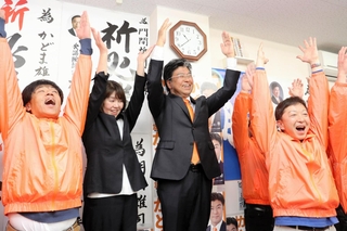 豊岡市長選に初当選し、万歳して喜ぶ門間雄司氏（中央）＝豊岡市寿町（撮影・大高　碧）