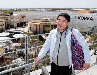 「行けば何か感じると思います」と語る磯部聡さん。上着は誘致時のスタッフ専用ウインドブレーカーだ＝大阪市此花区の夢洲