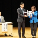 来賓の丸谷聡子明石市長（右）から色紙を受け取る西村康稔元経済産業相と、笑顔を見せる麻生太郎・自民党最高顧問＝４日午後、明石市中崎１