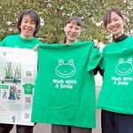 チャリティーウオークで着るＴシャツを手に参加を呼びかけるスタッフ＝神戸市中央区港島中町８