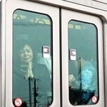 事故発生時刻近くに現場付近を通過する列車で手を合わせる乗客＝２５日午前９時２５分、尼崎市内（代表撮影）