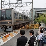 事故から２０年。祈りの杜の前を通過する電車＝２５日午前８時１４分、尼崎市久々知３（撮影・丸山桃奈）
