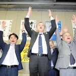 香美町長選で当選確実となり万歳する浜上勇人氏（中央）＝香美町香住区香住