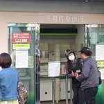 利用できなくなった三井住友銀行の出張所前で関係者の説明を受ける人ら＝２９日午後、神戸市中央区元町通１