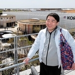 「行けば何か感じると思います」と語る磯部聡さん。上着は誘致時のスタッフ専用ウインドブレーカーだ＝大阪市此花区の夢洲