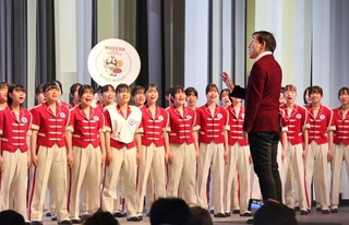 大阪・関西万博会場で「しあわせ運べるように」の合唱指揮をする臼井真さん＝８日午前、大阪市此花区の夢洲