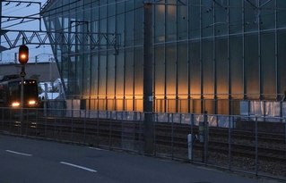 事故から丸２０年。一番電車のライトが祈りの杜を照らす＝２５日午前５時１０分、尼崎市久々知３（撮影・笠原次郎）