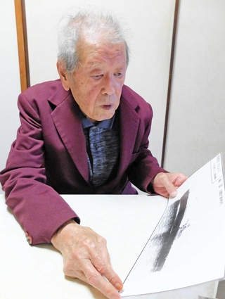 香椎丸の写真を手に「まだほんま子どもやった」と振り返る小西茂雄さん＝神戸市長田区