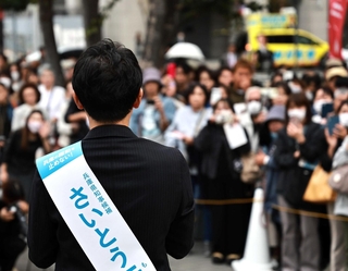 斎藤元彦氏の街頭演説では、近くに「ＮＨＫから国民を守る党」の黄色い街宣車（右奥）が控えた＝２０２４年１０月、神戸市内