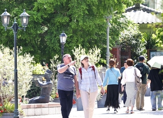 薄着で散策を楽しむ観光客ら。中には半袖姿も＝１３日午後、神戸市中央区北野町３