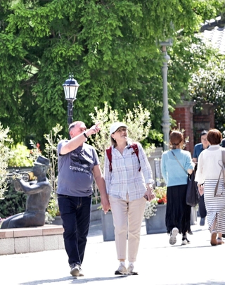 薄着で散策を楽しむ観光客ら。中には半袖姿も＝１３日午後、神戸市中央区北野町３