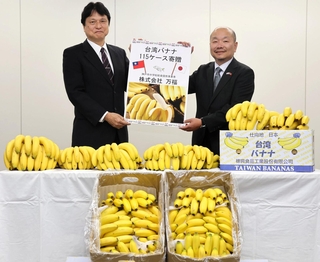 台湾産バナナを寄贈した万福の鳩山誠志代表取締役（右）と福本靖教育長＝神戸市中央区東川崎町１、市教育委員会