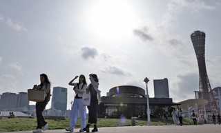 日差しが照りつける中、日傘を差して散策を楽しむ観光客たち＝20日午後、神戸市中央区（撮影・丸山桃奈）