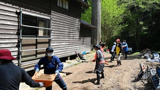 かき出した泥をリレーで運ぶ生徒ら＝石川県能登町、光明寺（啓明学院高校提供）