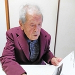 香椎丸の写真を手に「まだほんま子どもやった」と振り返る小西茂雄さん＝神戸市長田区