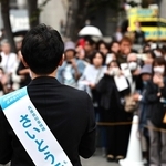 斎藤元彦氏の街頭演説では、近くに「ＮＨＫから国民を守る党」の黄色い街宣車（右奥）が控えた＝２０２４年１０月、神戸市内