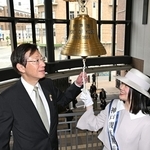 神戸まつりの成功を願って「繁栄の鐘」を鳴らす久元喜造神戸市長（左）と神戸観光親善大使の鈴木南帆さん＝１５日午前、神戸市中央区新港町、神戸ポートオアシス（撮影・風斗雅博）