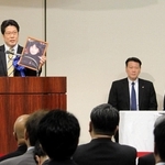 有本恵子さんの写真を手に、被害者の早期帰国を訴えた家族会の横田拓也代表（左）。右端は石破茂首相＝東京都千代田区
