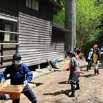 かき出した泥をリレーで運ぶ生徒ら＝石川県能登町、光明寺（啓明学院高校提供）