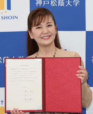 調印証明書を手にする南野陽子さん＝２日午後、神戸市灘区、神戸松蔭大学（撮影・丸山桃奈）