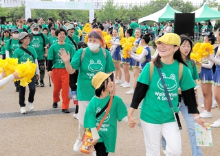 おそろいのＴシャツ姿で出発する参加者＝神戸市中央区小野浜町