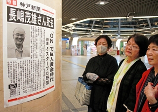 長嶋茂雄さんの死去を伝える号外を見る女性ら＝３日午前、神戸市中央区