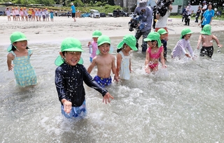 海に入って水遊びを楽しむ園児たち＝６日午前、兵庫県新温泉町の諸寄・塩谷浜海水浴場