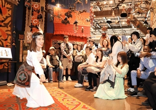 コモンズＡ館でキルギスの舞踊に見入る来場者ら＝いずれも大阪市此花区の夢洲