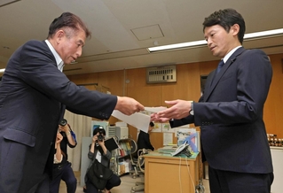 斎藤元彦知事（右）に辞職を求める申し入れ書を手渡すひょうご県民連合の上野英一幹事長＝１２日午後、神戸市中央区、兵庫県庁（撮影・笠原次郎）