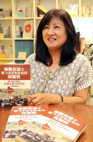 著書を手にボリビアからの学びを語る吉富志津代さん＝神戸市長田区海運町３