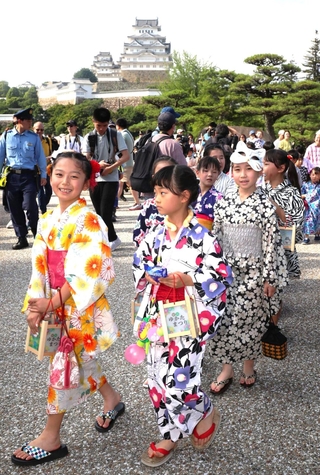 姫路城を背に浴衣姿でそぞろ歩きを楽しむ子どもたち＝２１日午後、姫路市本町（撮影・辰巳直之）