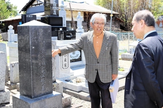 小池勇助軍医の遺族・小池清志さん（右から２人目）から墓を案内される久利計一さん＝長野県佐久市（ＫＯＢＥ三宮・ひと街創り協議会提供）