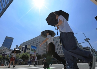 梅雨が明けて青空が広がった市街地。日傘を手にする人が目立った＝２７日午前、神戸市中央区（撮影・笠原次郎）