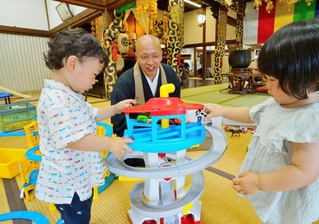 法衣姿で一緒に遊び、自ら「寺に親しみを持つ」ことを子どもたちに伝える渡邊崇俊住職（中央）＝丹波市青垣町東芦田