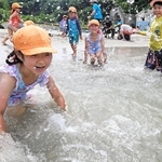 海に入って水をかけ合う園児たち＝６日午前、兵庫県新温泉町の諸寄・塩谷浜海水浴場