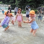 海に入って水をかけ合う園児たち＝６日午前、兵庫県新温泉町の諸寄・塩谷浜海水浴場