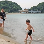 海辺で水遊びする親子連れ＝１６日午後、豊岡市竹野町竹野
