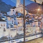 「訪れた人がぬくもりを感じられる商店街になれたら」。笹倉鉄平さんの作品「カダケス２０１０」のシャッター前で思いを語る中野レンガ坂商店会の岡田俊彦会長＝東京都中野区